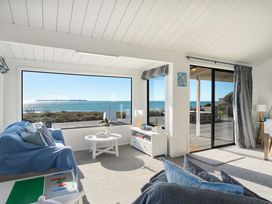 A living room with a view of the ocean at Sandbanks, Papamoa Holiday Home Papamoa