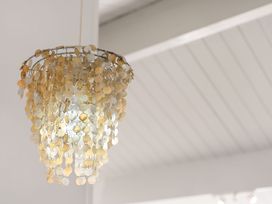 A chandelier in a room at Sandbanks, Papamoa Holiday Home