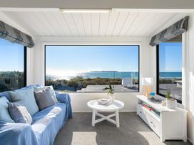 A snug with a sofa and table at Sandbanks, Papamoa Holiday Home in Papamoa