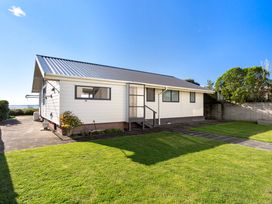 A house with a pathway and grass at Sandbanks, Papamoa Holiday Home, Papamoa
