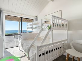A bedroom with a bunk bed and a view of the water at Sandbanks, Papamoa Holiday Home in Papamoa