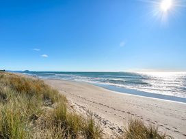 A beach with footprints in the sand at Sandbanks, Papamoa Holiday Home, Papamoa