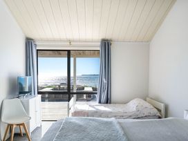 A bedroom with two beds and a television at Sandbanks, Papamoa Holiday Home