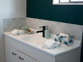 A bathroom sink with towels and toiletries at Calden Cottage - Ngurunguru Holiday Home Ngunguru