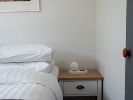 A bedroom with a bed and bedside table at Calden Cottage - Ngurunguru Holiday Home