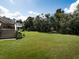A garden with grass and trees at Calden Cottage - Ngurunguru Holiday Home Ngunguru
