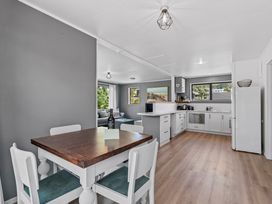 Dining area with table and chairs next to kitchen at Calden Cottage - Ngurunguru Holiday Home, Ngunguru