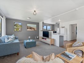 A living room with a sofa and television at Calden Cottage - Ngurunguru Holiday Home Ngunguru