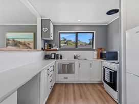 A kitchen with appliances and a window at Calden Cottage - Ngurunguru Holiday Home in Ngunguru