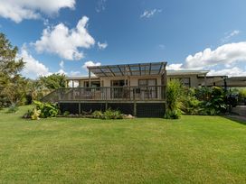 A house with a deck and garden at Calden Cottage - Ngurunguru Holiday Home Ngunguru