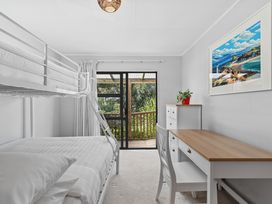 A bedroom with a bunk bed and a desk at Calden Cottage - Ngurunguru Holiday Home Ngunguru