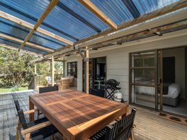 An outdoor area with a table and chairs at Calden Cottage - Ngurunguru Holiday Home Ngunguru