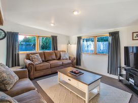 A living room with a sofa, coffee table and television at Thimble Cottage, Ashburton Holiday Home, Methven