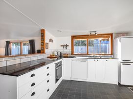 A kitchen with cabinets, sink, fridge and countertop at Thimble Cottage, Ashburton Holiday Home Methven