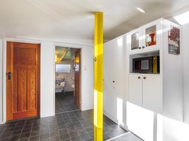 A bathroom with a door leading to a separated area at Thimble Cottage, Ashburton Holiday Home in Methven