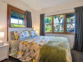 A bedroom with a bed and windows at Thimble Cottage Ashburton Holiday Home Methven