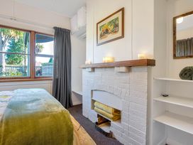 A bedroom with a bed and a fireplace at Thimble Cottage, Ashburton Holiday Home in Methven