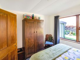 A bedroom with a bed and wardrobe at Thimble Cottage, Ashburton Holiday Home Methven