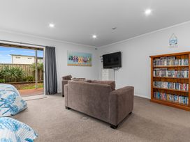 A living room with a sofa and a television at Seaside Escape - Ruakaka Holiday Home Ruakaka