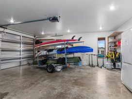 A garage with kayaks and surfboards on a trailer at Seaside Escape in Ruakaka