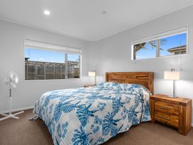 A bedroom with a bed and two nightstands at Seaside Escape - Ruakaka Holiday Home Ruakaka