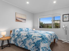A bedroom with a bed and bedside table at Seaside Escape - Ruakaka Holiday Home Ruakaka