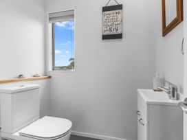 A bathroom with a toilet and sink at Seaside Escape - Ruakaka Holiday Home Ruakaka