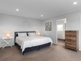 A bedroom with a bed and nightstands at Seaside Escape - Ruakaka Holiday Home Ruakaka