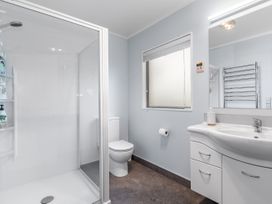A bathroom with shower, toilet, and sink at Seaside Escape - Ruakaka Holiday Home Ruakaka