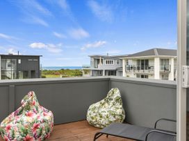 An outdoor terrace with bean bags overlooking the sea at Seaside Escape - Ruakaka Holiday Home Ruakaka