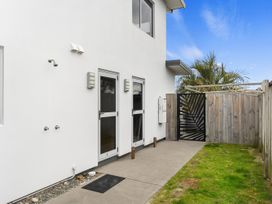 An outdoor area with pathways, a tap, and a fence at Seaside Escape - Ruakaka Holiday Home in Ruakaka