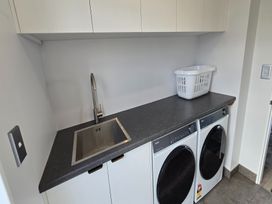 A laundry room with a sink and appliances at Seaside Getaway - Ruakaka Holiday Home Ruakaka