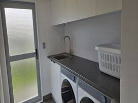 A laundry room with a washing machine and dryer at Seaside Getaway - Ruakaka Holiday Home Ruakaka