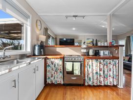 A kitchen with appliances and a counter at Coastal Hideaway - Waipu Cove Holiday Home in Waipu