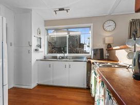 A kitchen with sink and window at Coastal Hideaway - Waipu Cove Holiday Home Waipu