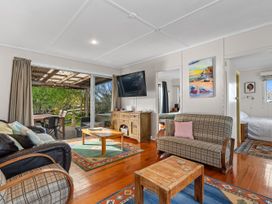 A living room with a television and sofa at Coastal Hideaway - Waipu Cove Holiday Home Waipu