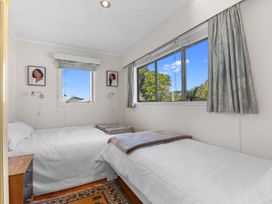 A bedroom with twin beds and windows at Coastal Hideaway - Waipu Cove Holiday Home, Waipu