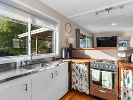 A kitchen with a stove and sink at Coastal Hideaway - Waipu Cove Holiday Home, Waipu