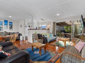A living room with sofas and a table at Coastal Hideaway - Waipu Cove Holiday Home Waipu