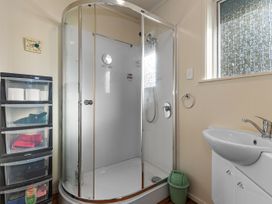 A bathroom with a shower and hand basin at Coastal Hideaway - Waipu Cove Holiday Home in Waipu