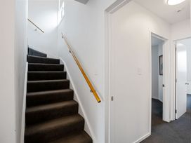 A staircase with a handrail in a stairway at Urban Oasis - Christchurch Holiday Home, Christchurch