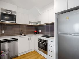 A kitchen with appliances and cabinets at Urban Oasis - Christchurch Holiday Home Christchurch