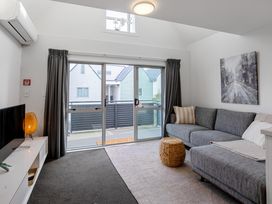 A living room with a sofa and television at Urban Oasis - Christchurch Holiday Home in Christchurch