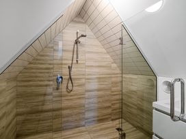 A shower with glass door and tiled walls at Urban Oasis - Christchurch Holiday Home Christchurch