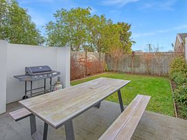 A garden with a table and barbecue grill at Urban Oasis - Christchurch Holiday Home, Christchurch