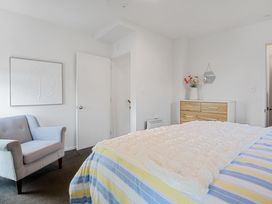 A bedroom with a bed and a chair at Urban Oasis - Christchurch Holiday Home Christchurch