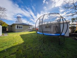 A garden with a trampoline and a house at Quiet on Quintin - Te Anau Holiday Home in Te Anau