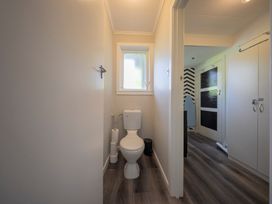 A bathroom with a toilet and window at Quiet on Quintin - Te Anau Holiday Home, Te Anau