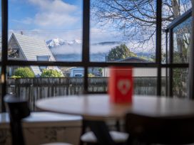 A dining room with a view of mountains and houses at Quiet on Quintin - Te Anau Holiday Home Te Anau