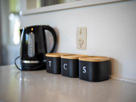 A kettle and storage containers in a kitchen at Quiet on Quintin - Te Anau Holiday Home